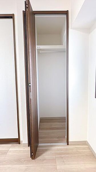 【リフォーム済】北側7帖洋室の収納写真です。半間分の枕棚（パイプ付き）を設置しました。コートなどの丈の長い洋服も収納できます。