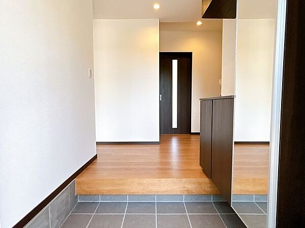 【リフォーム済】玄関内部です。シューズボックス新設、300角タイル重張、照明交換を行いました。ご家族の靴が収納できてすっきりしますね。