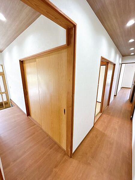 【リフォーム済】廊下です。床材重ね張り、壁天井クロス張替、照明器具交換を行いました。各部屋や水回りへ続きます。