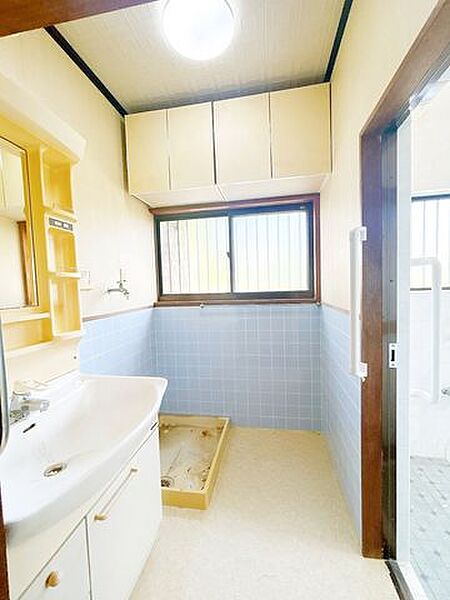 洗面脱衣室です。吊り戸棚がついているので、タオルや家族の洋服をしまえます。