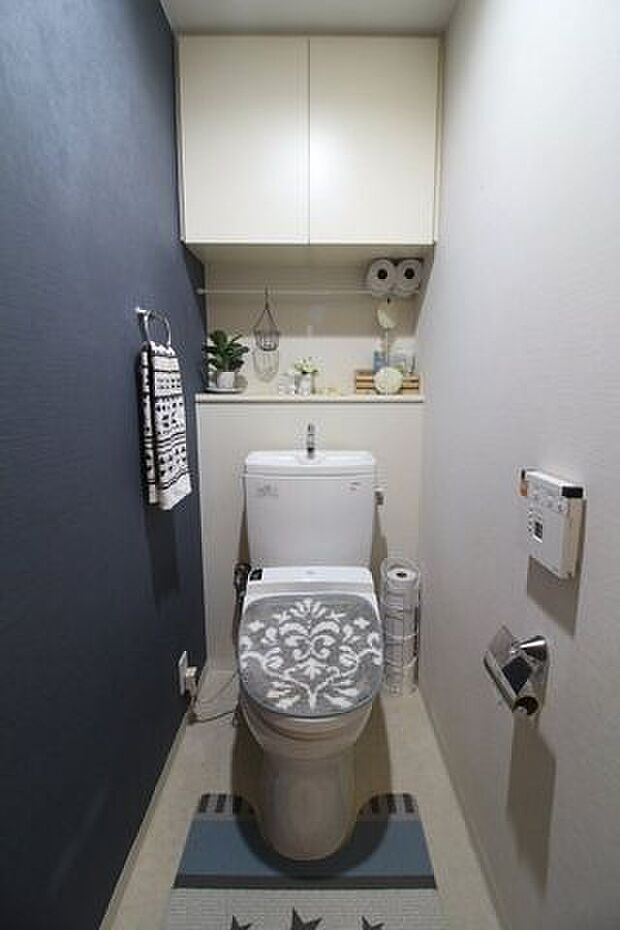 アクセントクロスがお洒落なウォシュレット付きのトイレです。収納スペースがあるのも嬉しいですね。