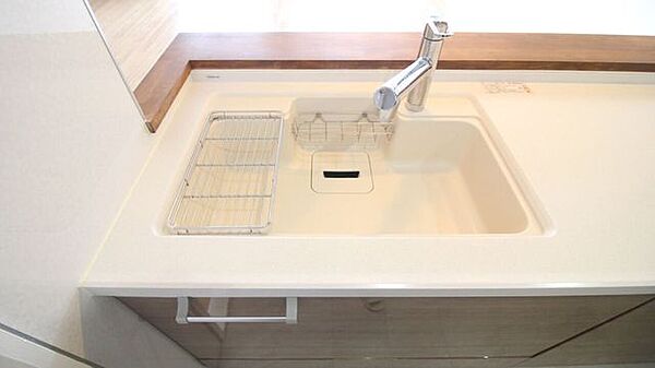 キッチン全体を明るく見せる上品なシンク。洗剤やスポンジがすっきり収まるポケット付きで、水回りを綺麗に保てます。