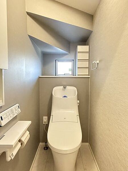 階段下スペースを活用した1階トイレ。収納棚付きで、トイレットペーパーや掃除道具なども収納でき便利です！