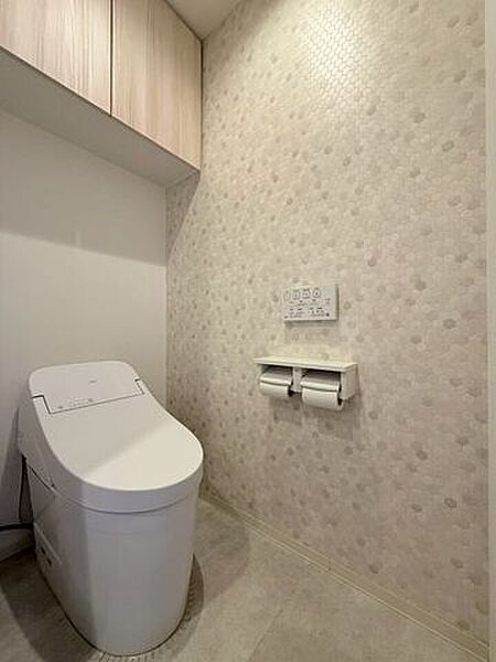 ウォシュレット付きのトイレです。収納スペースもあるので便利ですね！アクセントクロスもお洒落です♪