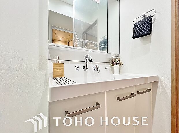 シャワー機能付きの洗面台には使いやすい横長ボウル、スマートに収まる収納と充実しています。
