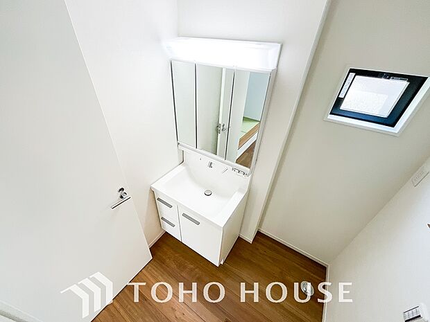 シャワー機能付きの洗面台には使いやすい横長ボウル、スマートに収まる収納と充実しています。