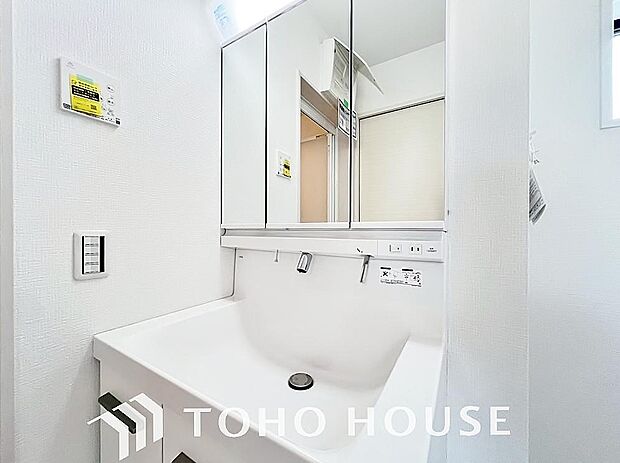 シャワー機能付きの洗面台には使いやすい横長ボウル、スマートに収まる収納と充実しています。