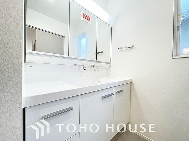 シャワー機能付きの洗面台には使いやすい横長ボウル、スマートに収まる収納と充実しています。