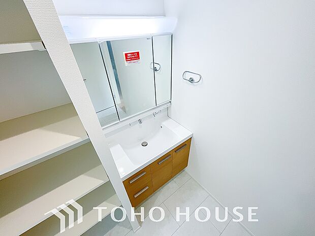 シャワー機能付きの洗面台には使いやすい横長ボウル、スマートに収まる収納と充実しています。