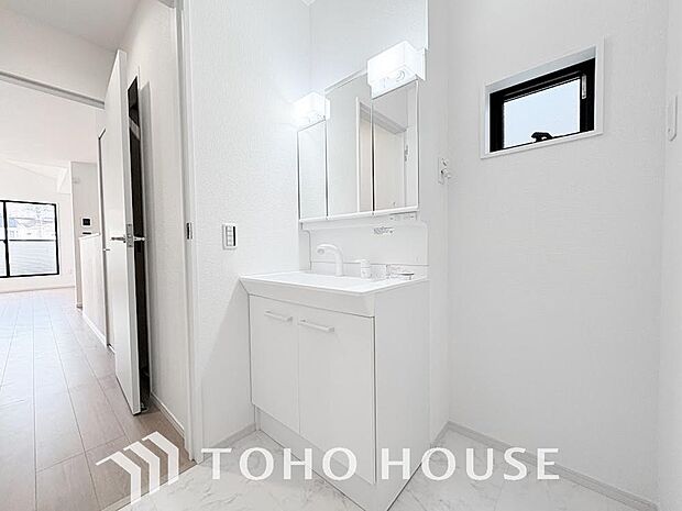 シャワー機能付きの洗面台には使いやすい横長ボウル、スマートに収まる収納と充実しています。