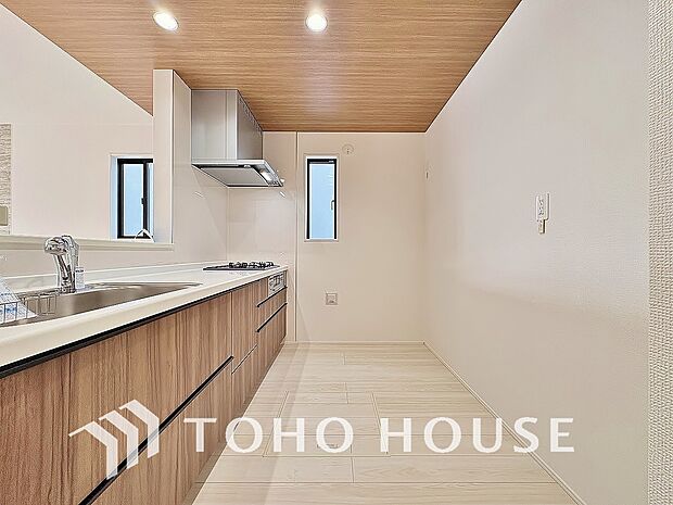 ポップアップ天井を採用したカフェスタイルキッチン。空間を惹き立てるアクセントクロスの美しさ、作業スペースの確保からお料理の受け渡しまでらくらくの機能性を兼ね備えた、魅力たっぷりの設計がされました。