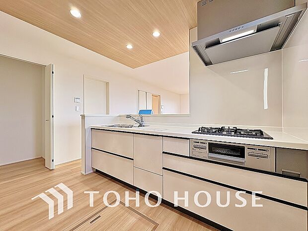 ポップアップ天井を採用したカフェスタイルキッチン。空間を惹き立てるアクセントクロスの美しさ、作業スペースの確保からお料理の受け渡しまでらくらくの機能性を兼ね備えた、魅力たっぷりの設計がされました。