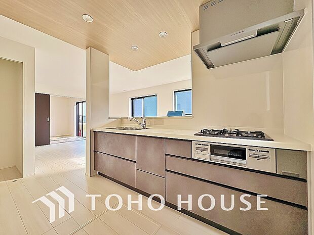 ポップアップ天井を採用したカフェスタイルキッチン。空間を惹き立てるアクセントクロスの美しさ、作業スペースの確保からお料理の受け渡しまでらくらくの機能性を兼ね備えた、魅力たっぷりの設計がされました。