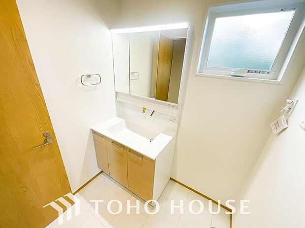 シャワー機能付きの洗面台には使いやすい横長ボウル、スマートに収まる収納と充実しています。