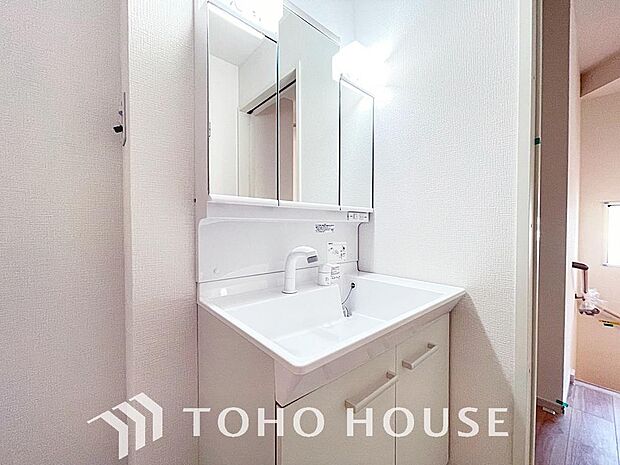 シャワー機能付きの洗面台には使いやすい横長ボウル、スマートに収まる収納と充実しています。