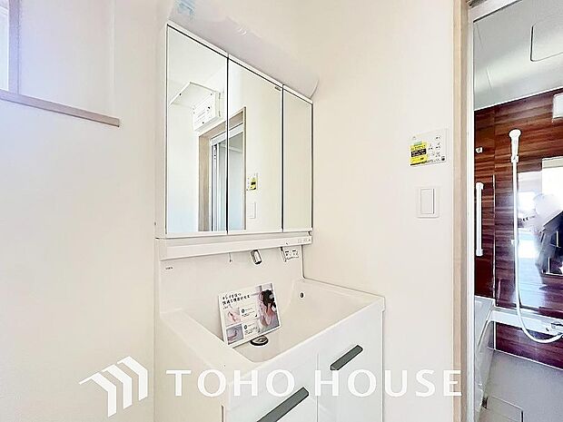 シャワー機能付きの洗面台には使いやすい横長ボウル、スマートに収まる収納と充実しています。