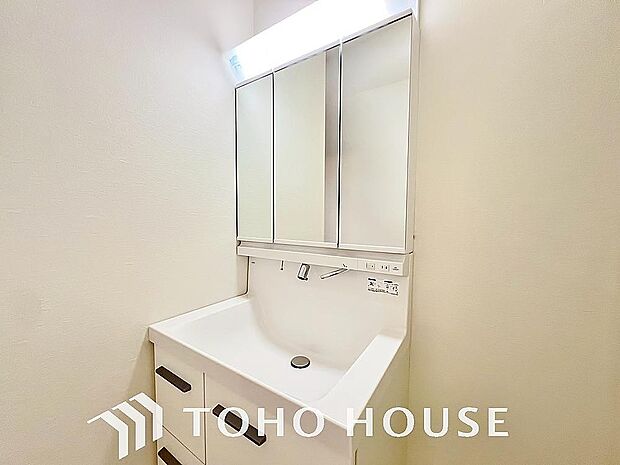 シャワー機能付きの洗面台には使いやすい横長ボウル、スマートに収まる収納と充実しています。