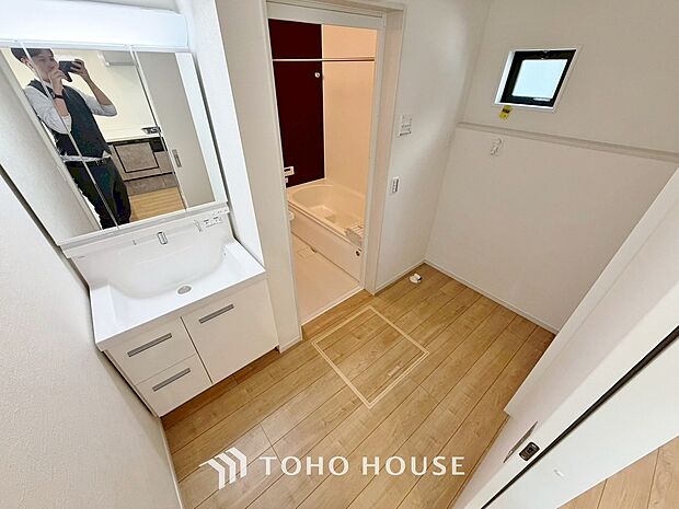 明るく清潔感のある洗面室には、機能的な三面鏡と使いやすい収納付き洗面台、洗濯機置場も備えています。