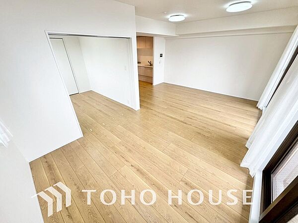 家族が集う一戸建ての広々としたリビング。大きな窓から明るい光が差し込み、開放感にあふれた空間です。家具の配置も自由自在で、家族団らんの時間を心地よく演出。家族の笑顔と会話が自然と弾む住まいの中心です。