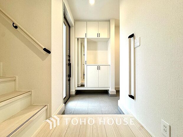 明るい光が差し込む広々とした新築戸建ての玄関です。毎日の出入りが楽しみになるような、清潔感にあふれた開放的な空間が広がっています。新生活の始まりを予感させる、洗練されたお住まいの顔を体感してください。