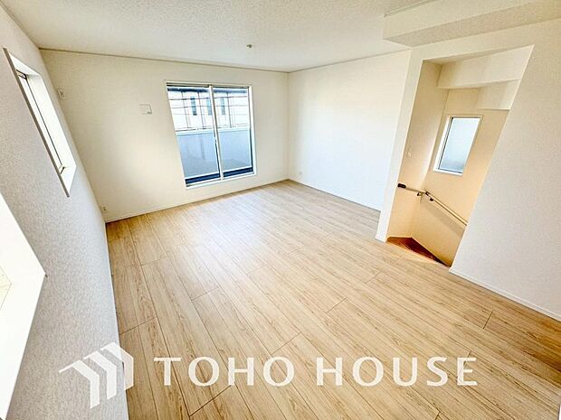 家族が集う一戸建ての広々としたリビング。大きな窓から明るい光が差し込み、開放感にあふれた空間です。家具の配置も自由自在で、家族団らんの時間を心地よく演出。家族の笑顔と会話が自然と弾む住まいの中心です。