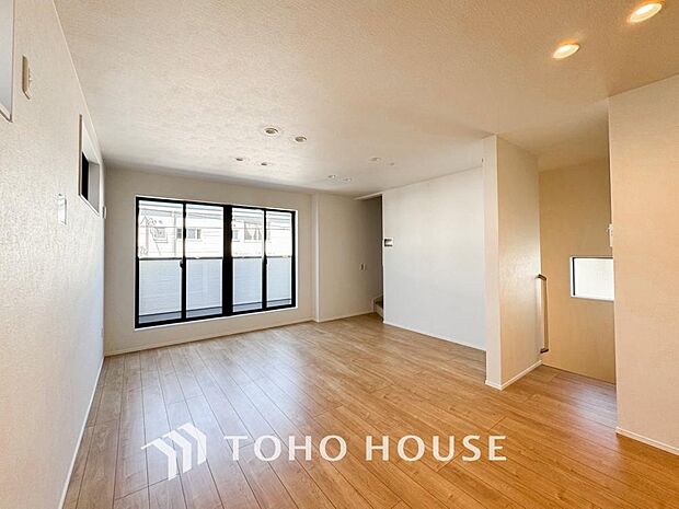 家族が集う一戸建ての広々としたリビング。大きな窓から明るい光が差し込み、開放感にあふれた空間です。家具の配置も自由自在で、家族団らんの時間を心地よく演出。家族の笑顔と会話が自然と弾む住まいの中心です。