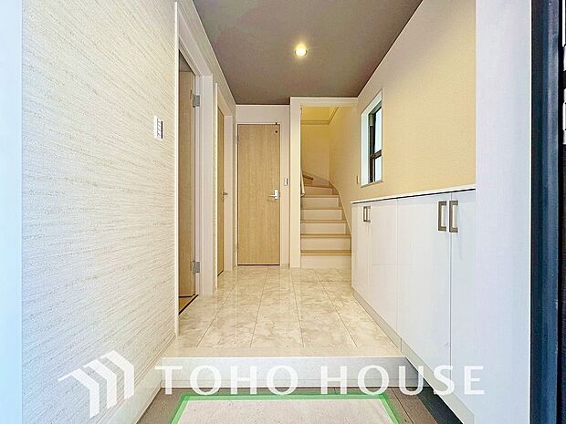 明るい光が差し込む広々とした新築戸建ての玄関です。毎日の出入りが楽しみになるような、清潔感にあふれた開放的な空間が広がっています。新生活の始まりを予感させる、洗練されたお住まいの顔を体感してください。
