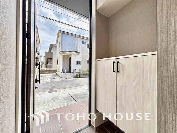 毎日みんなを見送り、そして明るい光が差し込む広々とした新築戸建ての玄関です。毎日の出入りが楽しみになるような、清潔感にあふれた開放的な空間が広がっています。新生活の始まりを予感させる、洗練されたお住ま