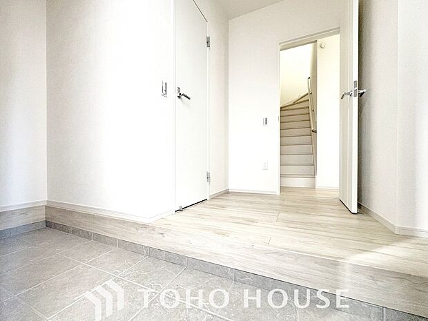 明るい光が差し込む広々とした新築戸建ての玄関です。毎日の出入りが楽しみになるような、清潔感にあふれた開放的な空間が広がっています。新生活の始まりを予感させる、洗練されたお住まいの顔を体感してください。