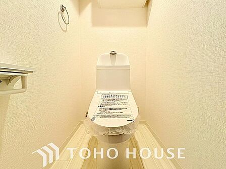 新規交換された、壁付リモコンの最新ウォシュレット付きトイレ。ご家族だけでなく来客やご友人も使うので、いつも清潔を保てるように配慮したい場所。見た目から清潔感あるようホワイトを基調にデザインされました。