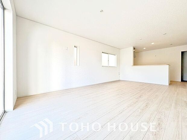 家族が集う一戸建ての広々としたリビング。大きな窓から明るい光が差し込み、開放感にあふれた空間です。家具の配置も自由自在で、家族団らんの時間を心地よく演出。家族の笑顔と会話が自然と弾む住まいの中心です。