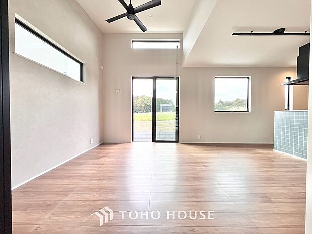 家族が集う一戸建ての広々としたリビング。大きな窓から明るい光が差し込み、開放感にあふれた空間です。家具の配置も自由自在で、家族団らんの時間を心地よく演出。家族の笑顔と会話が自然と弾む住まいの中心です。