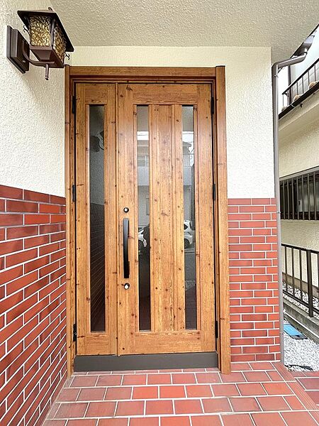 木目の美しい玄関ドアを新規交換。住まいの顔となる重厚感あるエントランスです。