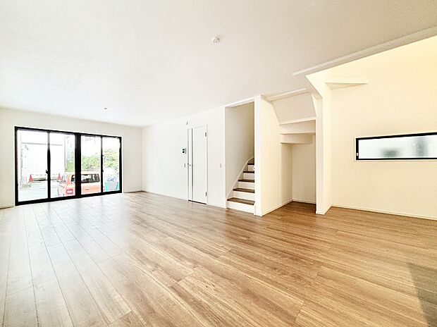 吹き抜けから明るい陽光が注ぎ、寛ぎの雰囲気に満たされるダイニング。