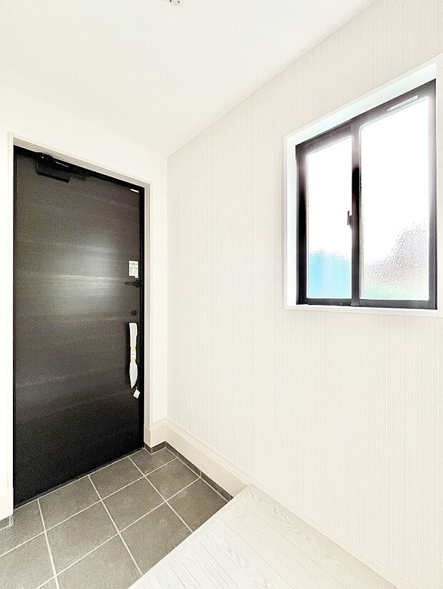 小窓から陽光を感じられる明るい玄関