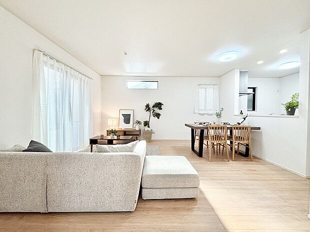 明るい陽光が注ぎ、寛ぎの雰囲気に満たされるリビング・ダイニング。  