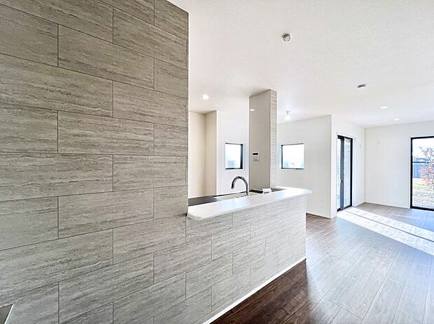 明るい陽光が注ぎ、寛ぎの雰囲気に満たされるリビング・ダイニング。 