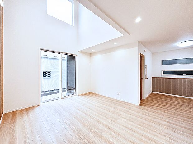 吹き抜けから明るい陽光が注ぎ、寛ぎの雰囲気に満たされるダイニング。