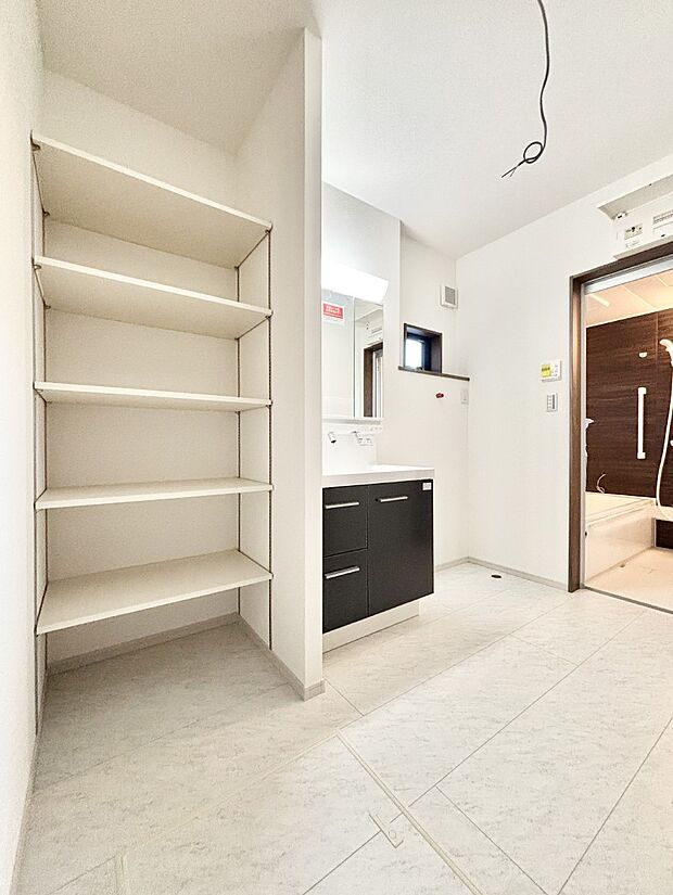 タオルや洗面用具のストック類を置ける便利な可動棚つきの脱衣場。