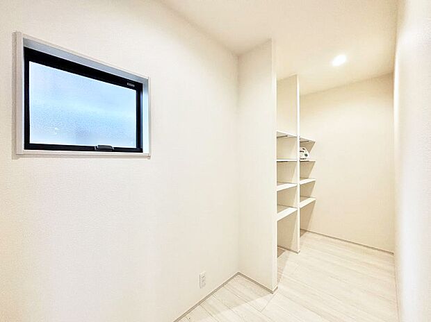 キッチン裏にある可動棚付きのユーティリティスペース。多用途にお使いいただけます。