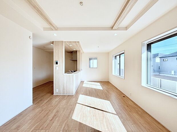 吹き抜けから明るい陽光が注ぎ、寛ぎの雰囲気に満たされるダイニング。