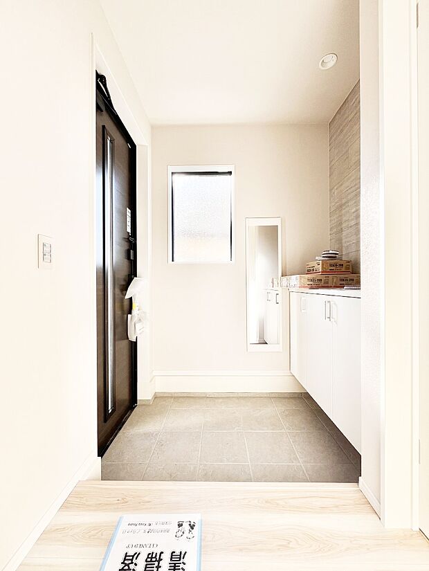 小窓から陽光を感じられる玄関