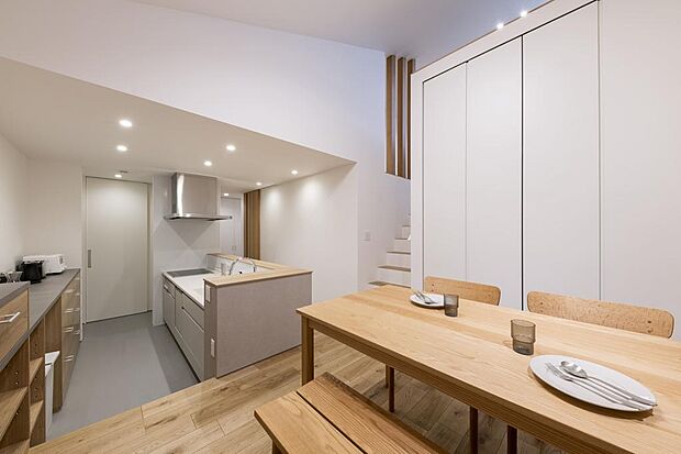 キッチン・ダイニング。ダイニングの背面には、壁面たっぷりの収納を設けました。収納の中に、Wi-Fiルーターを設置し、室内から見えない工夫がされています。