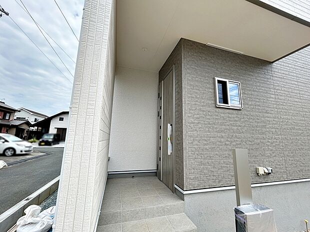 【玄関】 庇が広く、雨の日でも濡れにくい玄関ポーチです。玄関前で傘の開け閉めがしやすく、荷物が多い日でも落ち着いて出入りできます。毎日の外出や帰宅を快適にしてくれる、使い勝手の良い玄関まわりです。