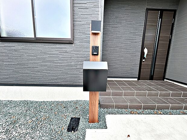 玄関前にはカメラ付インターホンとポストの一体型設備が設置されており、省スペースで玄関まわりがすっきりとまとまります。来訪者の確認や郵便物の受け取りもスムーズに行える、使い勝手の良い玄関まわりです。 