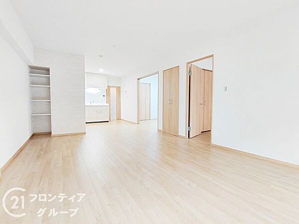 窓から差し込む柔らかな光が室内を明るく彩るリビングダイニングで、木のぬくもりを感じるフローリングと白い壁のコントラストが、開放的で心地よいプレミアムな住空間を作り上げています