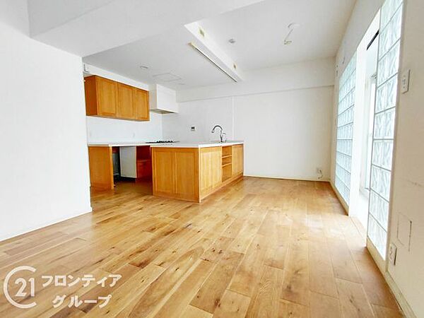 【リフォーム前】大きな窓から差し込む陽光が心地よい、開放感あふれるリビングルーム。木の温もりが感じられるフローリングが、家族で過ごす大切な時間を優しく包み込みます