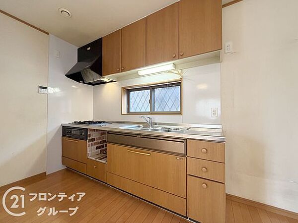 木目調のパネルが温かみを演出する機能的なシステムキッチンです。正面に窓があるため、明るい光の中で毎日のお料理を楽しく進められます。収納スペースも豊富で、いつもスッキリとした状態をキープできます