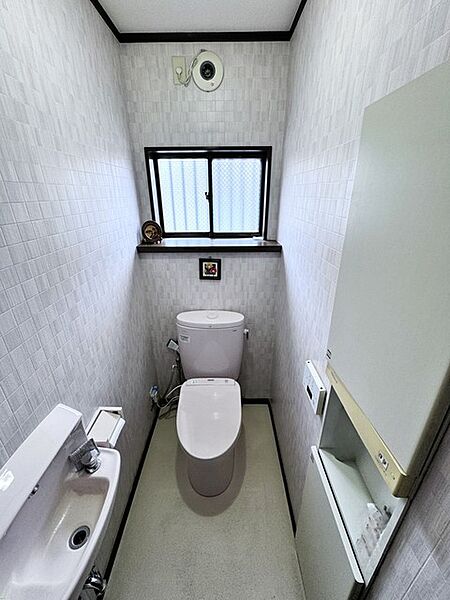 手洗い器や収納スペースを機能的に備えたトイレです。