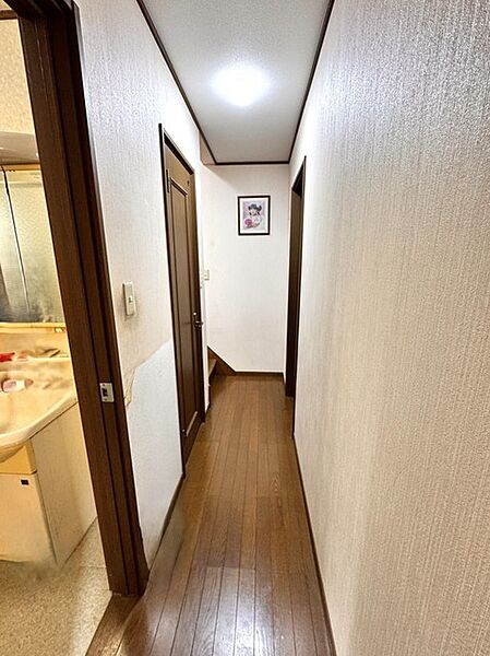 落ち着いた木目調の建具と壁の色味が調和し、住まいの中心として穏やかな時間が流れる玄関から続く廊下の空間です